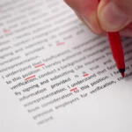 A red pen marking corrections on a printed page