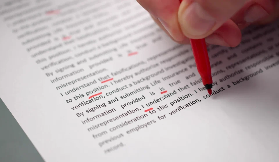 A red pen marking corrections on a printed page